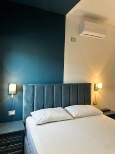 a bedroom with a large bed with a blue wall at Tirana Getaway Apartments - Central in Tirana