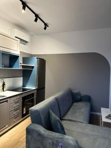 a living room with a couch and a kitchen at Tirana Getaway Apartments - Central in Tirana