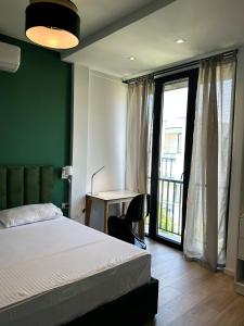 a bedroom with a bed and a desk and a window at Tirana Getaway Apartments - Central in Tirana