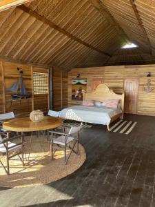 a bedroom with a bed and a table and chairs at Hostal velero relax in Playa Mendiguaca