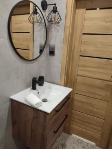 a bathroom with a sink and a mirror at Apartament ''Na Szlaku'' in Głuchołazy