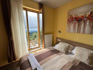 una camera da letto con un letto e una grande finestra di Hotel Zarja a Hočko Pohorje