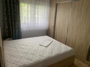 Una cama con una toalla blanca en un dormitorio en Villa Rejan, en Pogradec