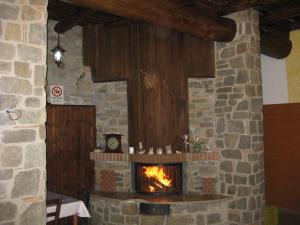 カステルメッツァーノにあるIl Molino Della Contessaの時計付きの部屋の石造りの暖炉