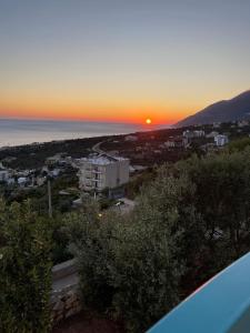 a sunset from the balcony of a house at Endless blue Apartments in Dhërmi