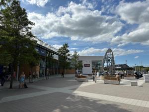 a shopping center with people walking in a plaza at Orchard House - Great Design, Comfortable furnitures, Free Wifi & Free Parking, Nice tidy Garden in Swindon