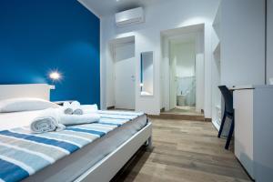 All'Imbarco في لا سبيتسيا: غرفة نوم زرقاء مع سرير عليه مناشف
