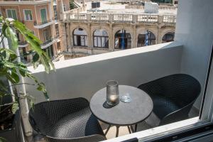 a small table and chairs on a balcony with a view at Loggia Suites by Good Life in Heraklio