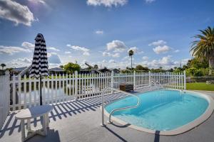 a swimming pool with chairs and a white fence at New Port Richey Oasis with Private Pool! in New Port Richey
