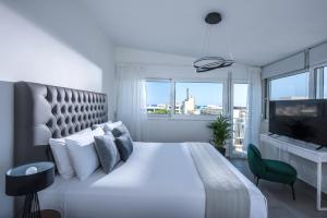 a bedroom with a white bed and a large window at Loggia Suites by Good Life in Heraklio +9 photos