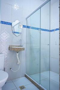 a bathroom with a shower and a sink and a toilet at Casa Jaguar suites 150 mt da praia geriba in Búzios