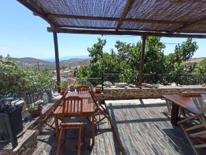 d'une terrasse sur le toit avec une table et des chaises. dans l'établissement Stone house Anatoli, à Mesokhória