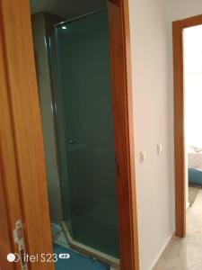a green glass shower door in a room at Appartement a gueliz in Marrakesh