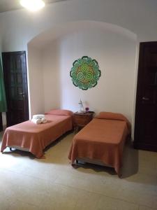 Habitación con 2 camas y una señal verde en la pared. en Casa Echevarria en Los Cocos