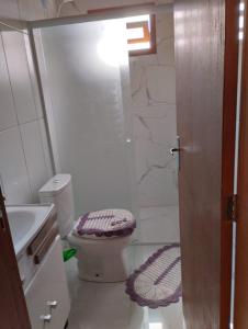 a bathroom with a toilet and a sink at Pousada Flor da Serra in Urubici