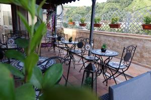 eine Reihe von Tischen und Stühlen auf einer Terrasse in der Unterkunft Hotel Kursaal in Neapel