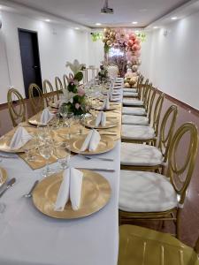 une grande table avec des chaises, des assiettes et des serviettes dans l'établissement Hotel Palmeras De Luz, à Moniquirá