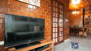 einen Fernseher auf einem Holzständer in einer Ziegelwand in der Unterkunft Refúgio Familiar-Casa de Campo em Gravata-3QTS-065 in Gravatá