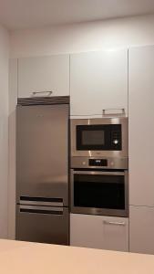 a kitchen with a stainless steel refrigerator and a microwave at A de Juan - Tres Marias Apartments in Redondela