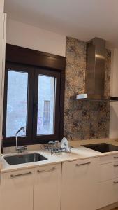 a kitchen with a sink and two windows in it at A de Juan - Tres Marias Apartments in Redondela