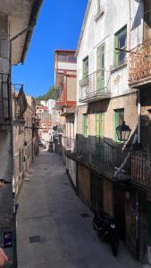 un callejón con una motocicleta estacionada junto a los edificios en A de Juan - Tres Marias Apartments, en Redondela