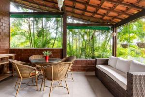 eine Terrasse mit einem Tisch, Stühlen und einem Sofa in der Unterkunft Refúgio Familiar-Casa de Campo em Gravata-3QTS-065 in Gravatá