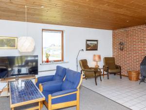 Frøstrupにある7 person holiday home in Fr strupのリビングルーム(青いソファ、椅子付)