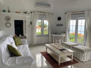 a living room with a white couch and a table at Ocean Garden, 4 units by the ocean in São Vicente