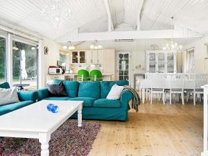 a living room with a blue couch and a kitchen at Holiday home Jerup VII in Jerup