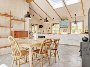 cocina con mesa de madera y sillas en Holiday home Jerup VI en Jerup