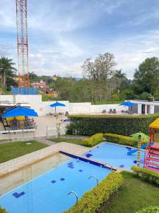 a large swimming pool in a park with a playground at Hotel Palmeras De Luz in Moniquirá