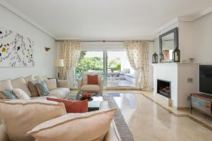 a living room with a couch and a fireplace at Los Monteros Palm Beach - ground floor apartment in Marbella
