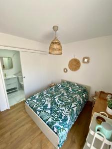 sypialnia z łóżkiem z zieloną i białą kołdrą w obiekcie Chambre Privée Accès Piscine w mieście Mimizan