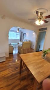 Addington的住宿－offering cheerfull and spacious rooms throught this 3 bed room semi detached house with large garden and off-street parking.，客厅配有桌子和吊扇