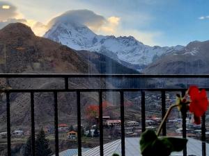a view of a snowy mountain range from a window at Hotel Sweet Night in Kazbegi