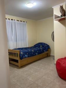 1 dormitorio con 1 cama con sábanas azules y ventana en Exclusiva casa céntrica en Chascomús