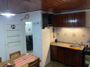 eine Küche mit einer Spüle, einem Kühlschrank und einem Tisch in der Unterkunft Exclusiva casa céntrica in Chascomús