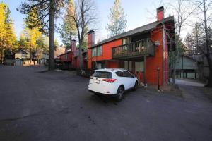 a white car parked in a parking lot next to a building at Next 2 Lift, Hot Tub, Massage Chair, Bbq, in Big Bear Lake