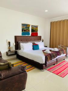 a bedroom with a large bed and a couch at Hotel Palmeras De Luz in Moniquirá