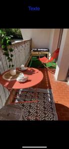 un tavolo rosso e una sedia sul balcone con tavolo di Appartement Cosy Montpellier a Montpellier