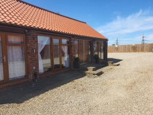 a brick house with glass doors and a roof at Thorpe Thewles Suites in Stockton-on-Tees