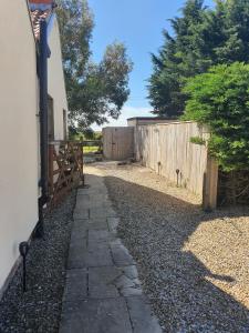 a stone path next to a fence next to a house at Thorpe Thewles Suites in Stockton-on-Tees