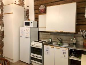 una cucina con elettrodomestici bianchi e armadietti bianchi di Guest House Nina Art a Kotka