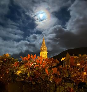 einen Blick auf einen Uhrturm mit dem Mond im Himmel in der Unterkunft BASIA, Lourdes - centre , quartier historique Sanctuaires a 7 min a pied in Lourdes
