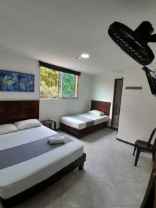 a bedroom with two beds and a large window at Hotel Palermo Real in Medellín