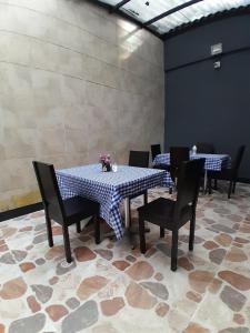 ein Esszimmer mit 2 Tischen und Stühlen mit Blumen darauf in der Unterkunft Hotel Palermo Real in Medellín