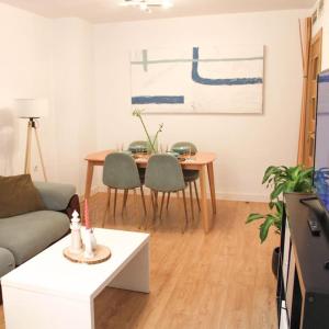 un soggiorno con divano e tavolo di Apartamento en Málaga Capital - Barrio de Teatinos a Málaga