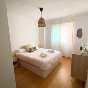 a bedroom with a white bed and a window at Apartamento en Málaga Capital - Barrio de Teatinos in Málaga