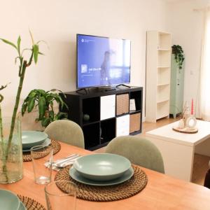 mesa de comedor con platos y TV en Apartamento en Málaga Capital - Barrio de Teatinos, en Málaga