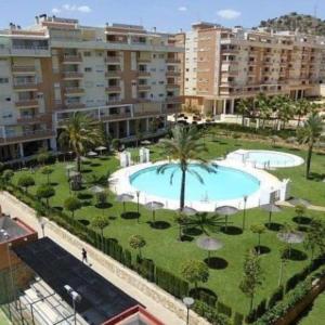 a large swimming pool with palm trees and buildings at Apartamento en Málaga Capital - Barrio de Teatinos in Málaga